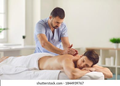 Therapist applying firm deep tissue pressure to a client's back